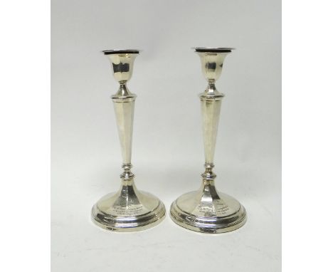 A pair of silver table candlesticks, each having a tapered octagonal column and on circular base, presentation inscribed, hei