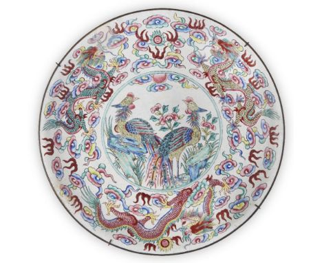 A Chinese Canton enamel 'dragon and phoenix' dish, Daoguang period, painted to the central reserve with phoenixes inside a bo