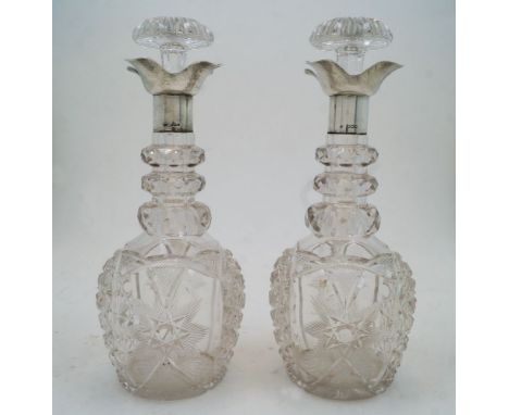 A pair of cut glass decanters and stoppers with silver collars, Sheffield, 1924, probably Walker &amp; Hall, marks rubbed, th