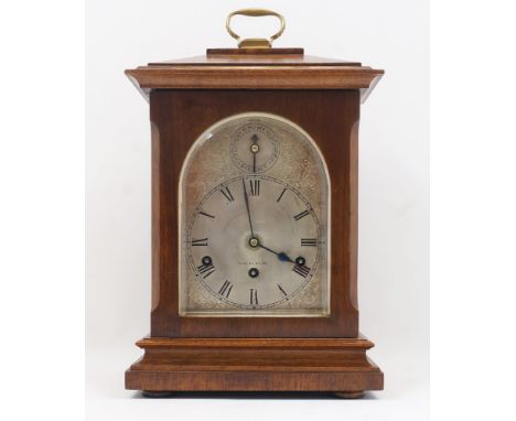 An Edwardian oak bracket clock, the silvered face and dial with Roman hours and subsidiary Chime/Silent dial, the German move