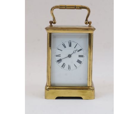 A French gilt-brass carriage clock, early 20th century, the corniche case with swing handle and bevelled glass panels on a pl