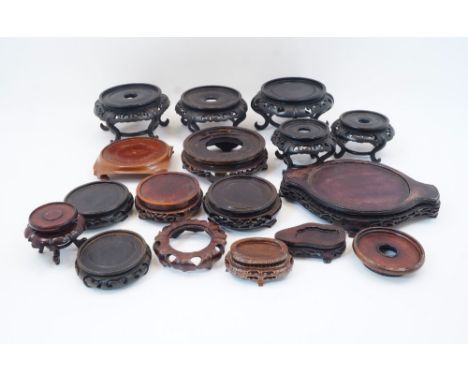 A collection of Chinese carved and pierced hardwood stands, 20th century, to include five circular examples raised on scrolli