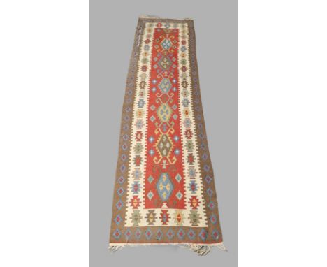 A Persian kilim runner, late 20th century, geometric design on a multi coloured ground, 305cm x 80cmone corner is badly damag