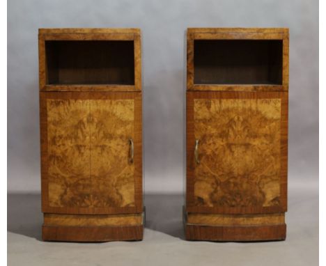 A pair of Art Deco walnut bow fronted bedside cabinets, with open shelf above cupboard door, raised on plinth base, 73cm high