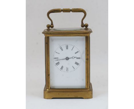 A French gilt-brass carriage clock, early 20th century, the corniche case with swing handle and bevelled glass panels, on pli