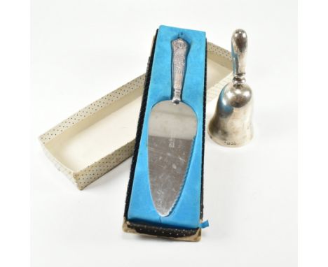 A hallmarked silver handled cake knife and bell. The cake knife having a  hallmarked silver handle and serrated edge and in i