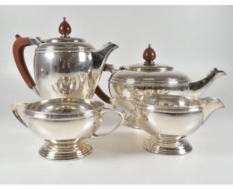 A Mappin and Webb hallmarked silver four piece tea service consisting of a tea and coffee pot, sugar bowl and creamer. The po