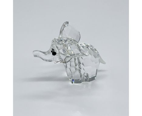 A clear faceted elephant with its ears out, trunk up, frosted tail, and black crystal eyes. Swarovski etched backstamp. This 
