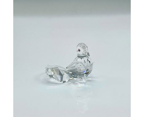 Clear faceted crystal figure of a dove with pink crystal eyes. Part of the Feathered Friends collection. Swarovski mark. This