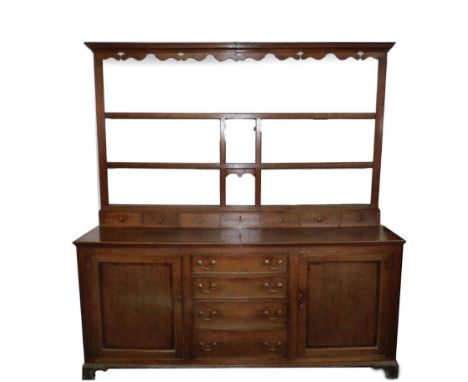 An 18thC oak dresser with plate rack, the upper part having moulded cornice and a fretwork frieze  and an arrangements of spi