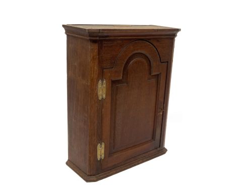 A George II oak hanging wall cupboard, with moulded cornice and single door with moulded and fielded arch panel, H hinges, 80