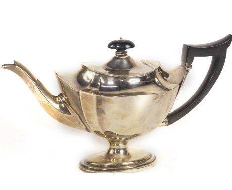 A late Victorian silver teapot, of fluted oval urn shaped design, with a hinged lid and supported upon a spreading oval stepp