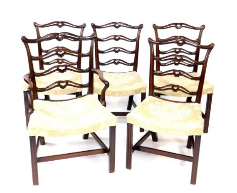 A set of five George III mahogany dining chairs in the Chippendale manner, including carver, having scroll terminal cresting 