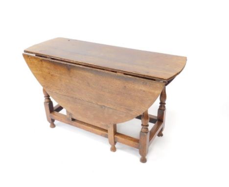 An early 18thC oak gate-leg table with oval drop leaf top, frieze drawer having knob handle on baluster and square framing te