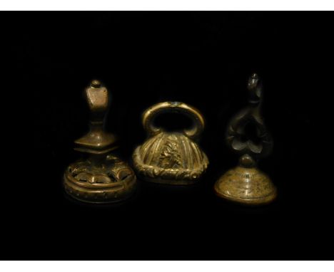 Three gilt metal seals, comprising one set with carved light purple stone with figure of a warrior, another set with red ston
