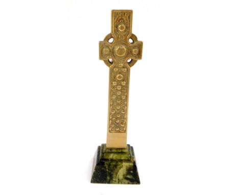 A brass Celtic Cross desk stand, cast with figures and animals, verso knots and scrolling flowers, raised on a stepped rectan