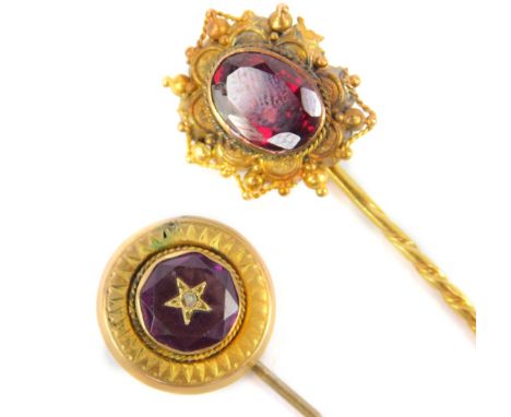 Two stick pins, comprising on with circular top, set with central amethyst stone, with star centre, set with seed peal, with 