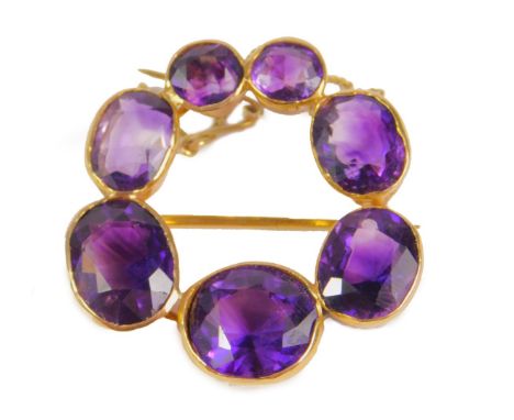 An amethyst circular brooch, set with varying sized amethyst stones, mainly oval cut, the largest stone 11mm wide, the smalle