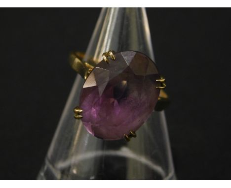 A 9ct gold amethyst dress ring, with large oval cut amethyst 16mm x 11.8mm x 7.8mm, in claw setting, with pierced basket, on 