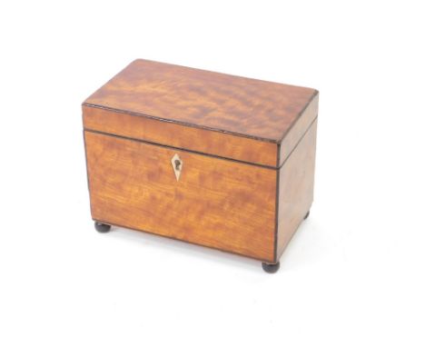 A George III mahogany tea caddy, with rosewood line inlay, the hinged lid opening to reveal a twin compartment, raised on bal