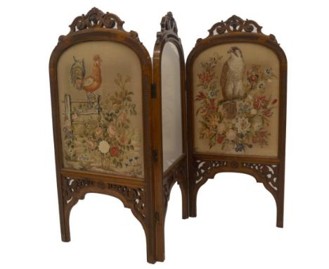 A Victorian walnut three fold screen, with carved scroll arch tops, with repeat decoration to the base, with clear glazed cen