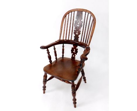 An early 19thC yew wood high back Windsor chair, with Christmas tree splat, bow arms, turned supports, ring turned legs and H