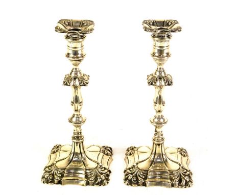 A pair of late Victorian silver candlesticks, of George II design, with detachable shaped square sconces and with slender bal