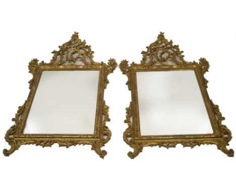 A pair of Chippendale revival giltwood and gesso pier glasses, each having rococo asymmetrical pediments with C and S scrolls