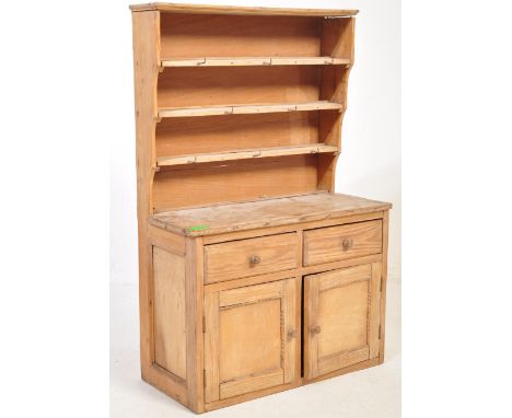 A vintage 20th Century pine dresser. Having a flared cornice to the top, three tiered plate rack, atop a dresser base with tw