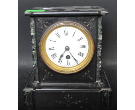 An early 20th century slate mantel clock having a flared top white enamel clock face with Roman numerals to the chapter ring 