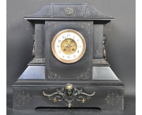 An early 20th century circa 1900 slate mantel clock of architectural form having a brass and enamel clock raised on a plinth 