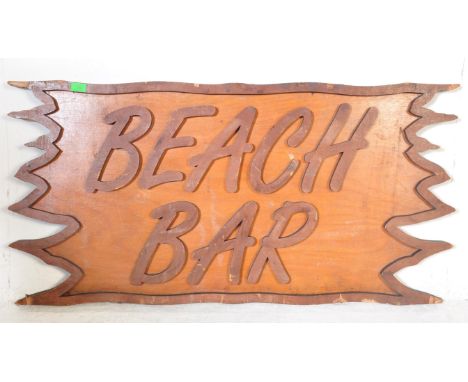 A vintage late 20th Century plywood Beach Bar sign. Cut to resemble a piece of driftwood with raised lettering to the centre.