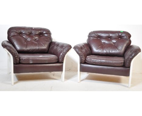 A pair of retro vintage mid 20th Century Danish armchair/lounge chairs. The chair having brown leather buttoned cushions. Wit