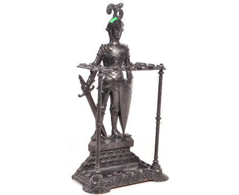 A vintage 20th century cast iron umbrella and stick stand in the form of a knight in armour with sword and shield atop a base