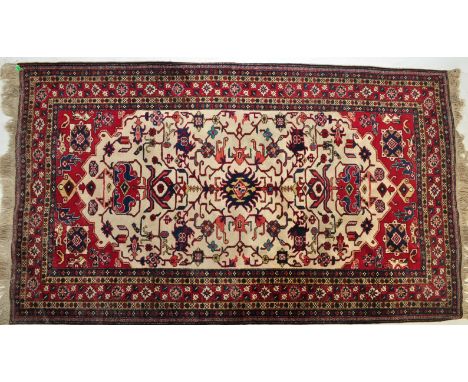 An early 20th century Persian Islamic Ardebil rug / carpet having a large cream medallion with polychrome floral decoration s