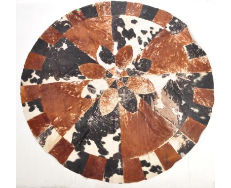 A large retro vintage mid 20th century circa 1970s circular patch work cow hide rug / carpet. Measures 230cm in diameter.