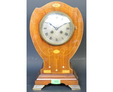 An early 20th century Edwardian circa. 1900 French oak case balloon clock. The mantle having inlaid florals to the case over 