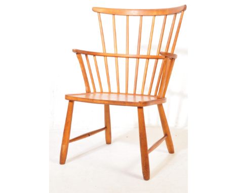 A 20th century Windsor style beech and elm chair having a comb back rest, saddle seat, shaped armrests raised on turned legs 