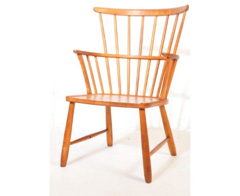 A 20th century Windsor style beech and elm chair having a comb back rest, saddle seat, shaped armrests raised on turned legs 