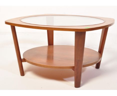 A retro vintage mid 20th century teak wood Astro style coffee table having a drop in circular glazed table top raised on upri