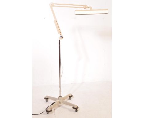 A large retro 20th century Luxo floor standing standard angle poise medical surgeons lamp in a white colourway raised upon ca