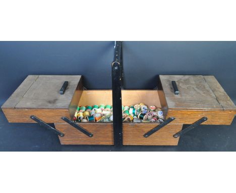 A vintage retro mid 20th century metamorphic teak sewing box having an ebonised handle atop with extending inner shelves with