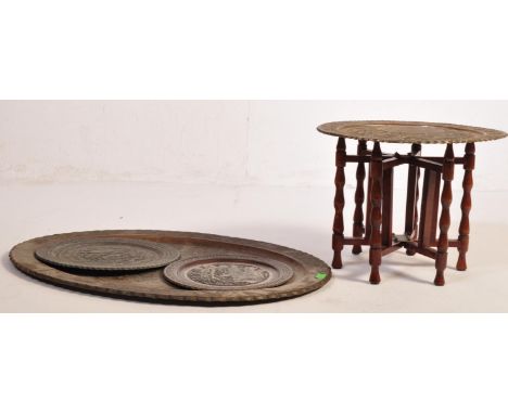 A large vintage 20th century Benares table of oval form. The table having inscribed geometric patterns raised on a wooden bas
