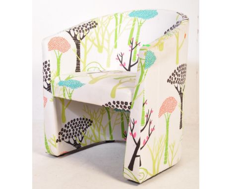 A retro vintage 20th century designer bucket armchair having stylised botanical upholstery raised on upright supports. Measur