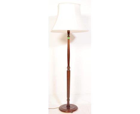 An early 20th Century circa 1930's mahogany standing lamp. The lamp having a white/cream lamp shade, turned body and a circul