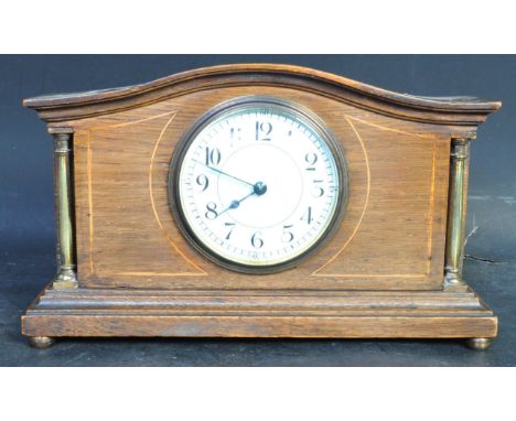 An early 20th century Edwardian circa. 1910 mahogany inlaid mantle clock with tambour top, enamelled face with Arabic numeral