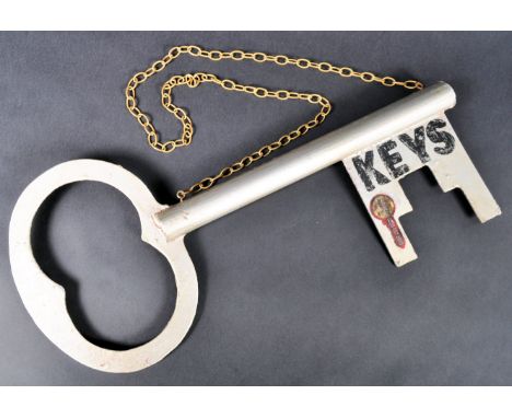 A vintage 20th Century Folk Art hanging shop display sign in the form of a key advertising for a Locksmith / Key Cutting shop