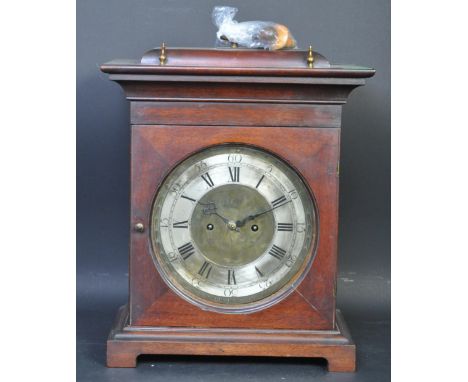 an early 20th century circa 1920s mantel clock having a mahogany case flared cornice circular glass raised on bracket feet. T