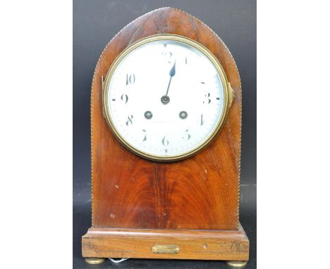 An early 20th century flamed mahogany mantle clock. The mantel clock being of arched form with white enamelled face and Arabi