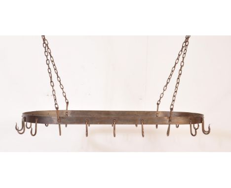 A vintage 20th century cast iron pheasant hanging rack having a band of metal festooned with hooks. The hanging rack has a ch